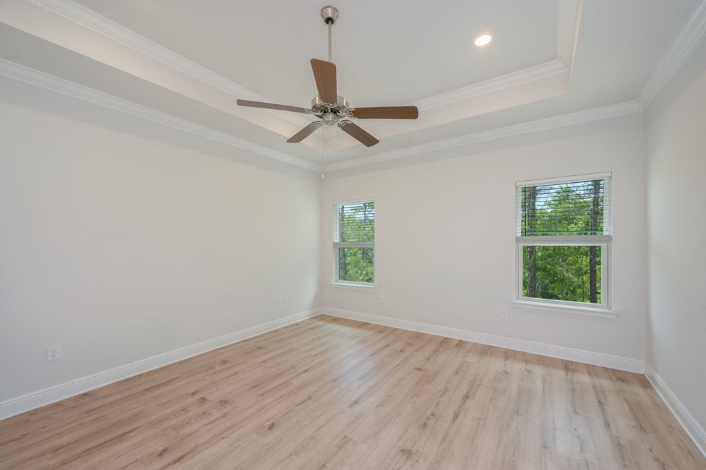 an empty living room with hardwood floors and a ceiling fan