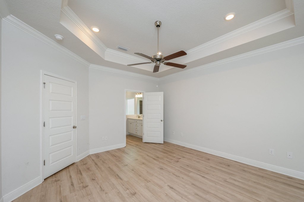 a living room with white walls and a ceiling fan
