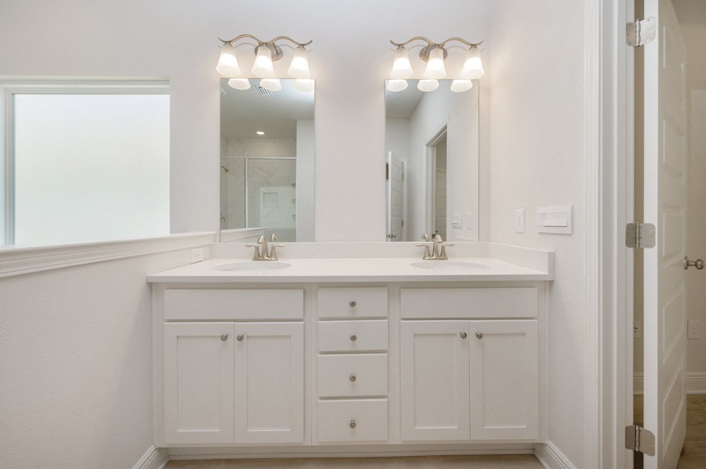 a white bathroom with two sinks and a mirror