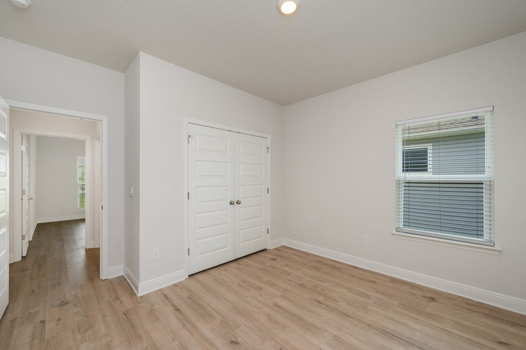 an empty bedroom with a closet and a window