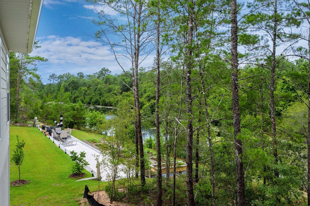 a view from a balcony of a river and trees