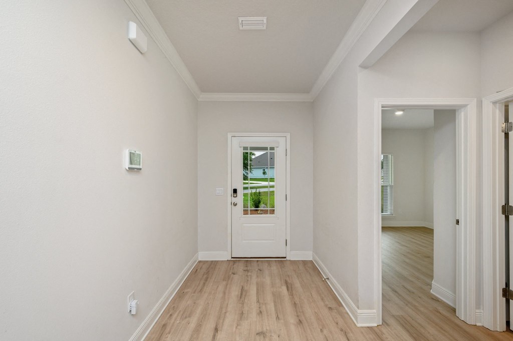 a living room with a white door and a wooden floor