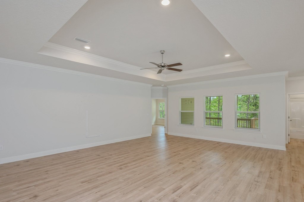 an empty living room with white walls and a ceiling fan
