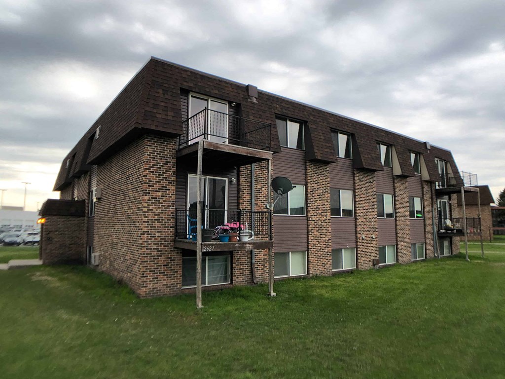 a brick apartment building with balconies on the side of it