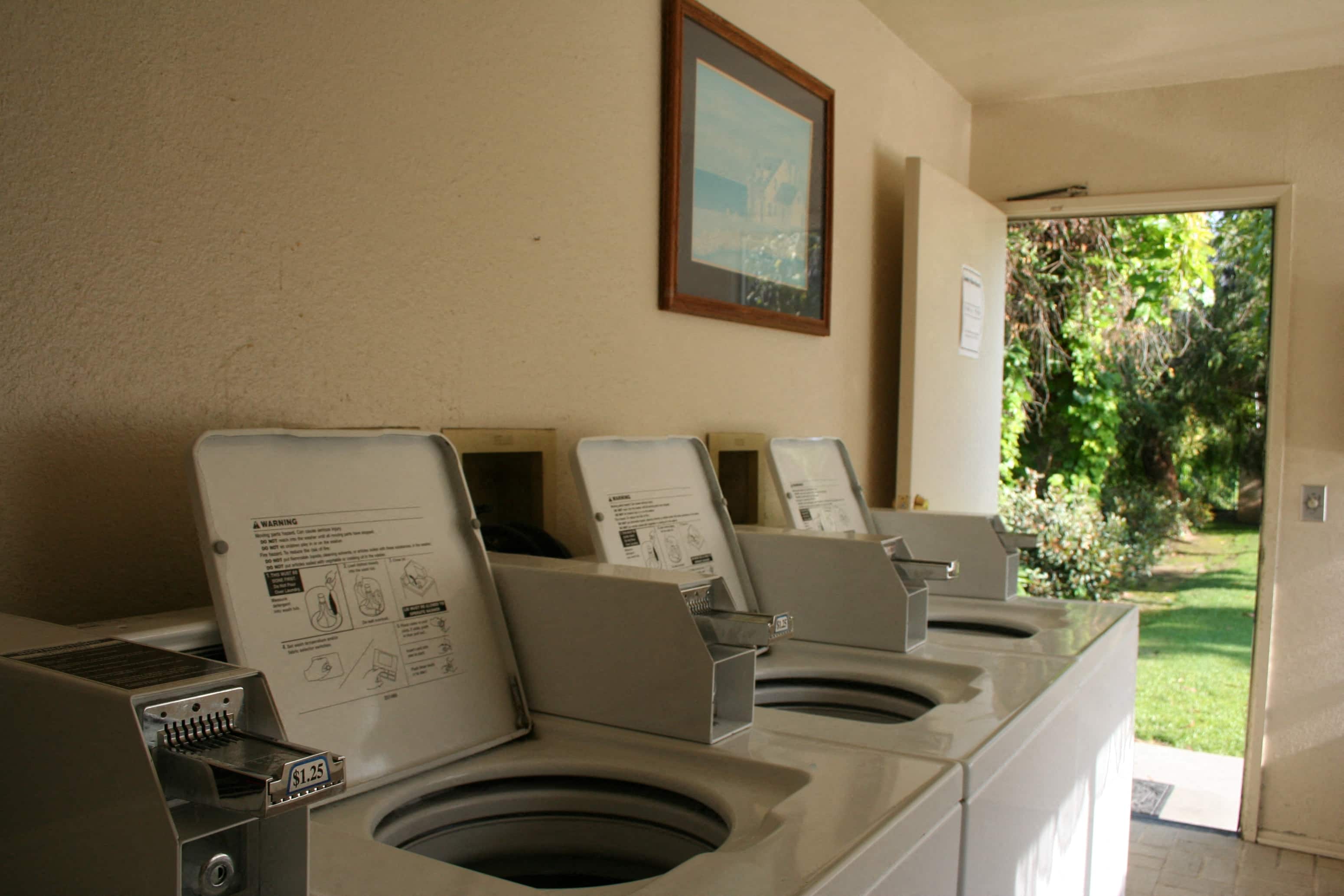 a row of washing machines in an outdoor laundry room