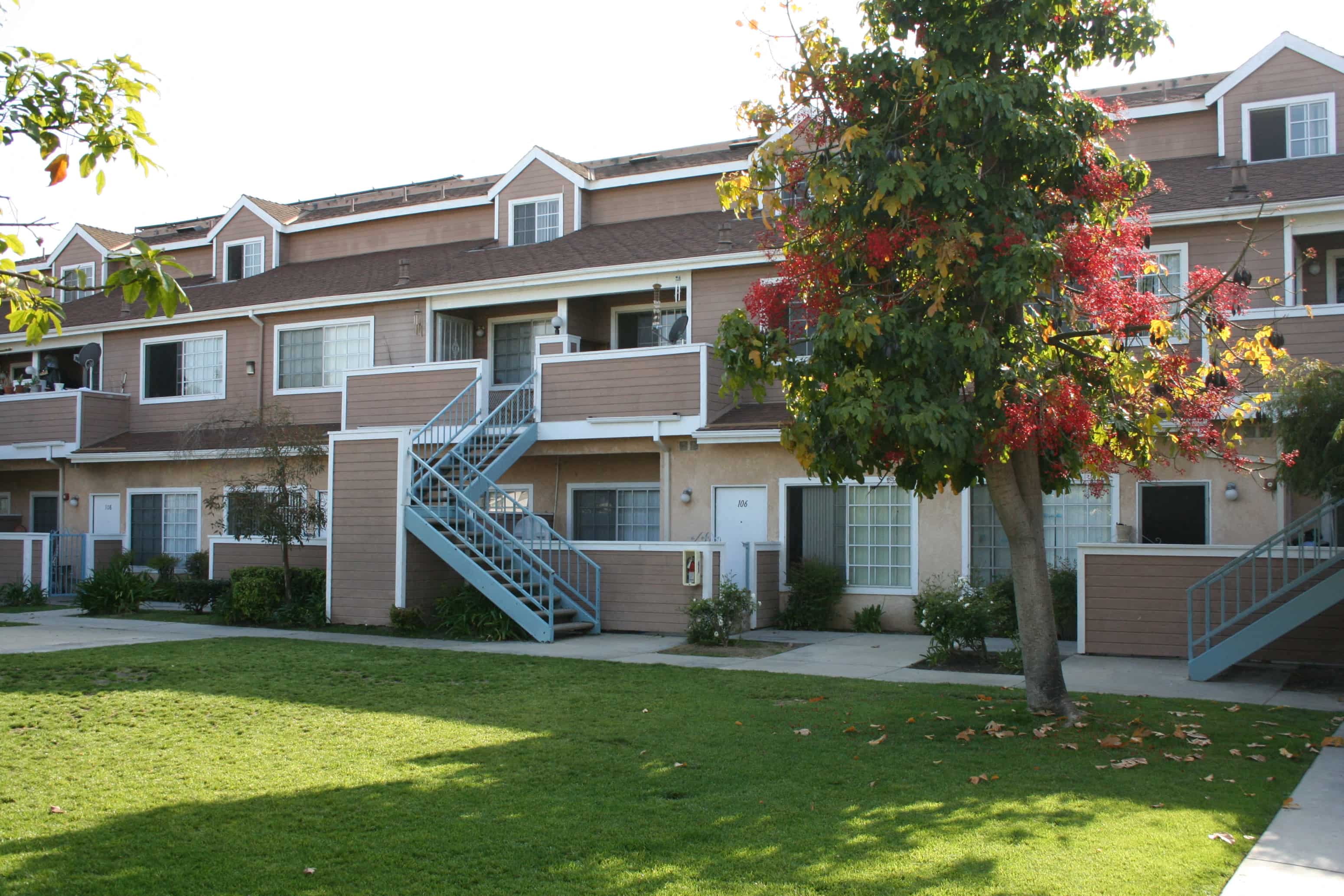 the outlook of an apartment building with balconies and a lawn