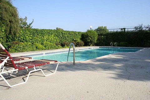 a swimming pool with two lounge chairs next to it