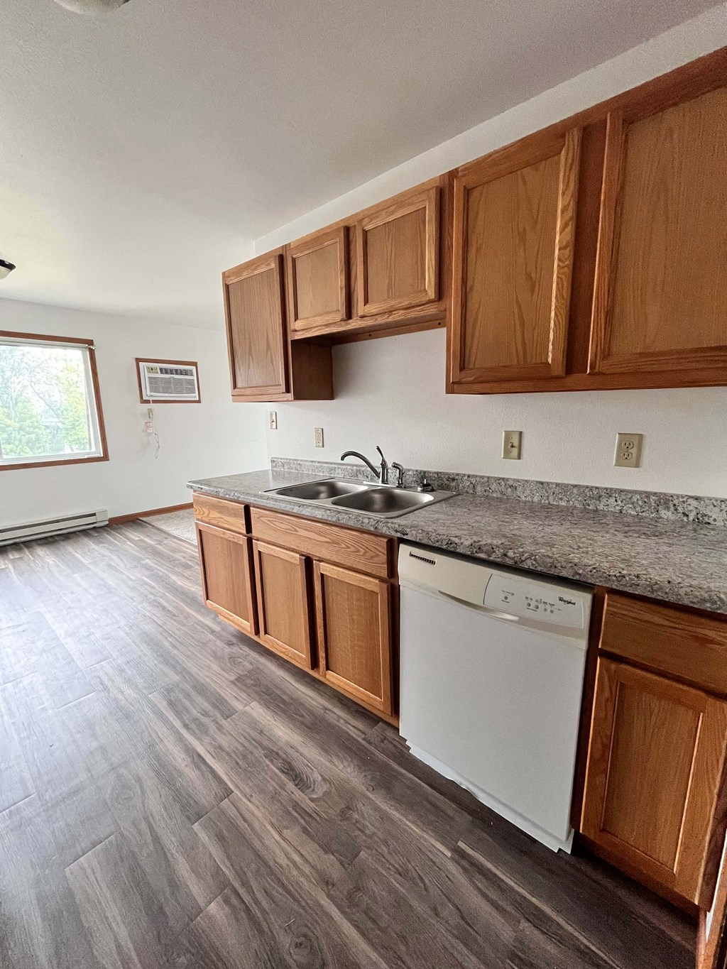 a kitchen with wooden cabinets and a sink and a dishwasher