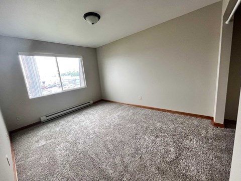 an empty room with carpet and a window