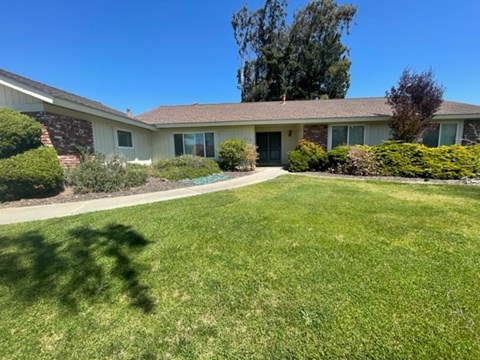 A house with a green lawn in front.