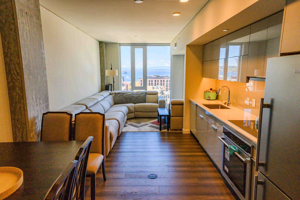 A kitchen with a refrigerator, oven, and sink.