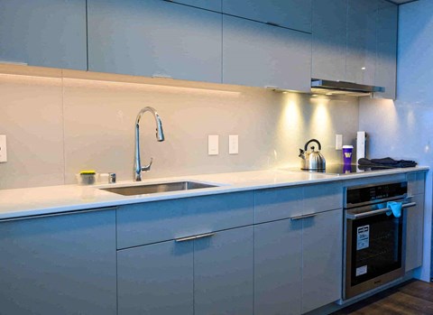 A modern kitchen with a sink and a stove.