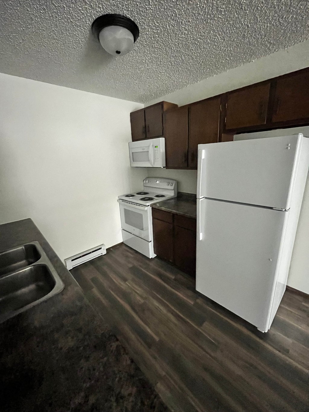 a kitchen with a refrigerator and a stove and a microwave