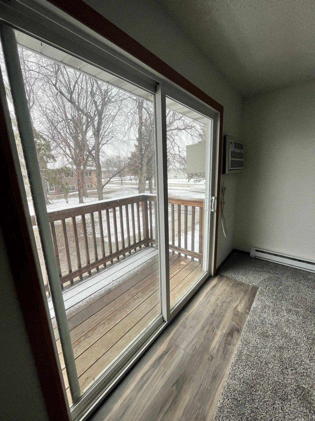 a sliding glass door leading to a porch with a wood deck
