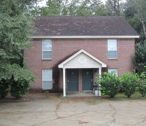 the front of a brick house with a blue door