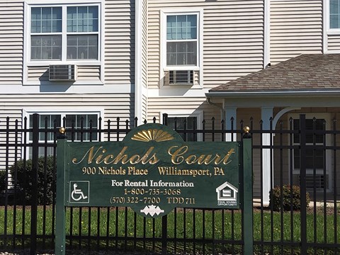 a neighborhood sign in front of a house