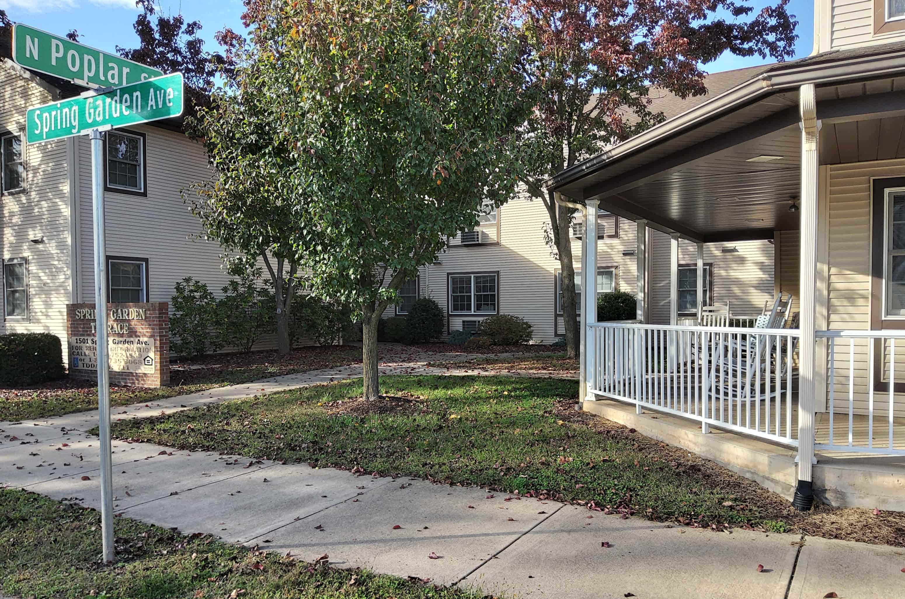 a sidewalk in front of a house with a street sign