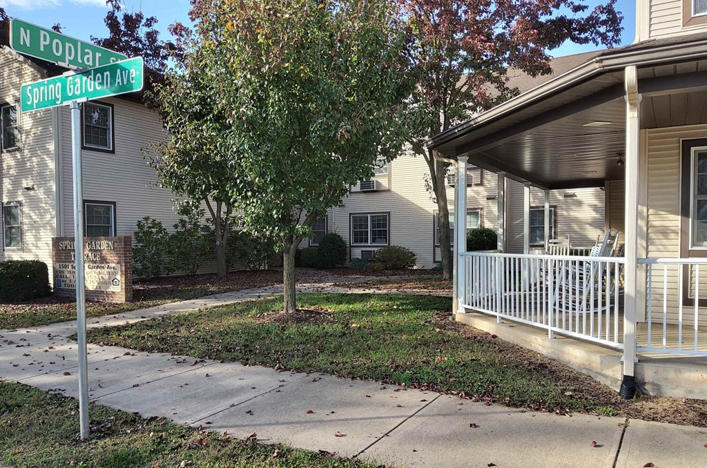 a sidewalk in front of a house with a street sign
