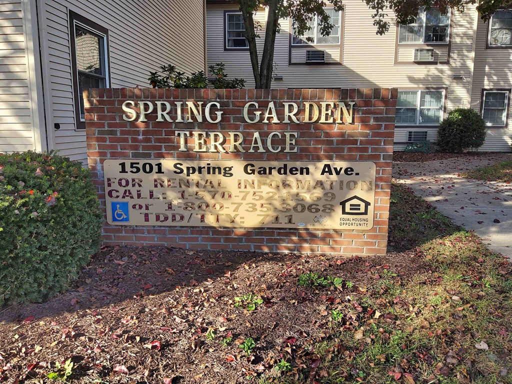 a sign for spring garden terrace in front of a house