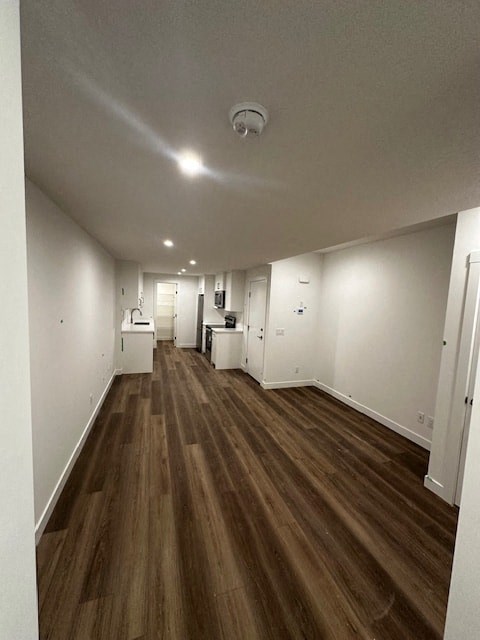 an empty living room and kitchen with wood floors