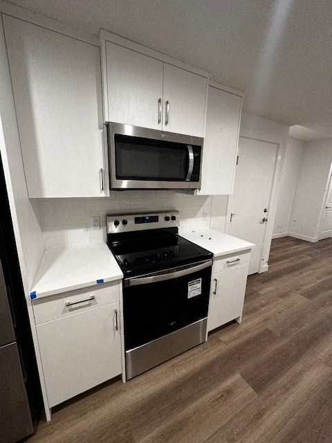 a kitchen with white cabinets and a stove and a microwave