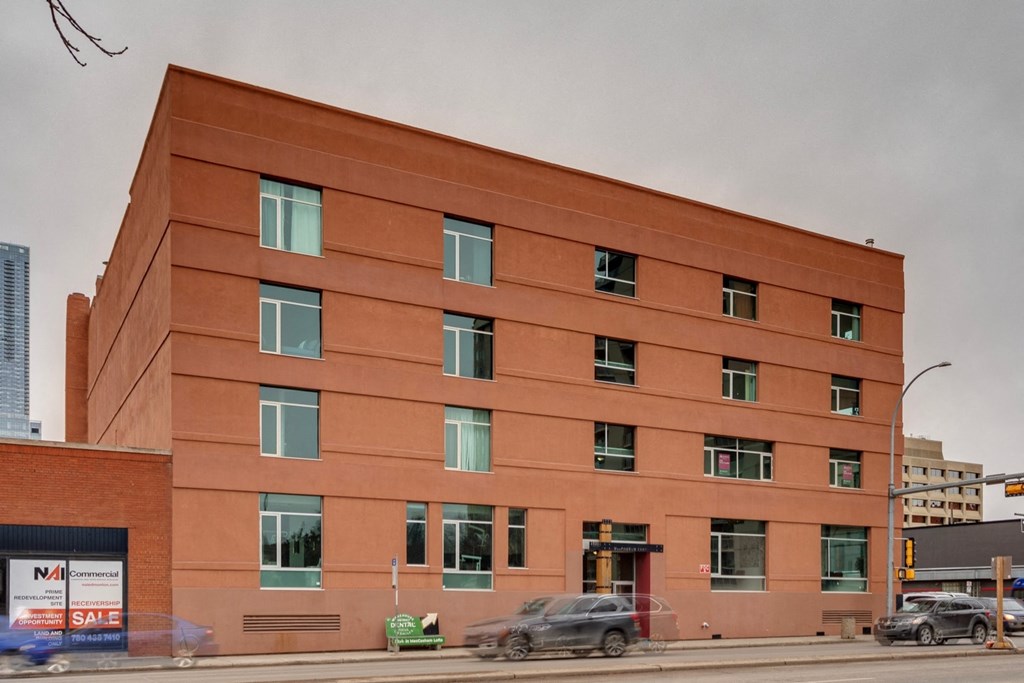 A red building with a sign that says "For Sale" on the left side.