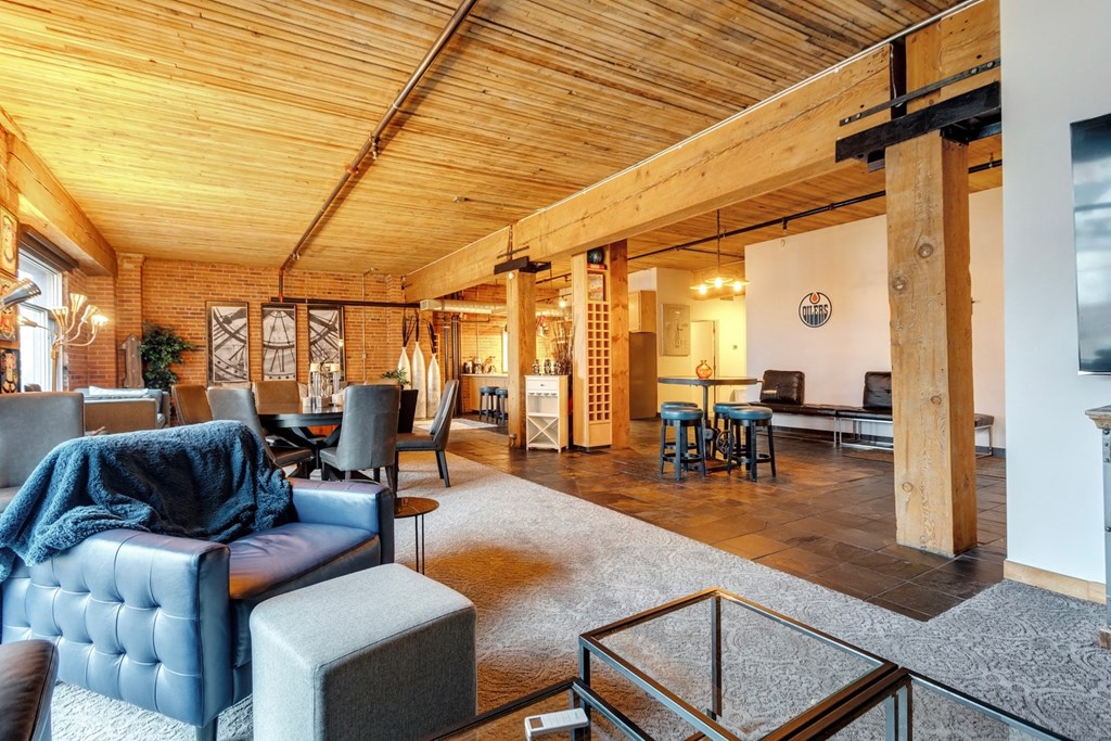 A modern living room with a wooden ceiling and a glass coffee table.