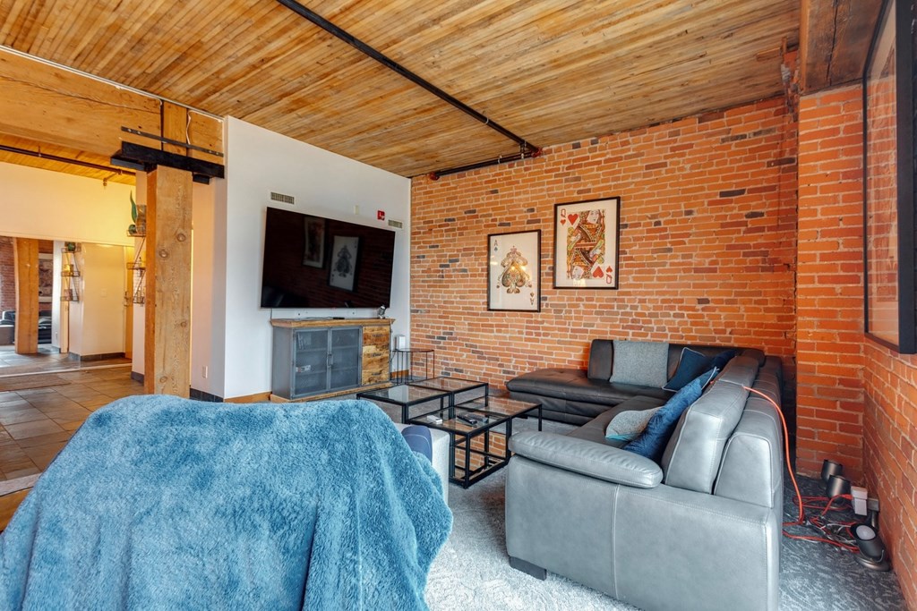 A living room with a grey couch and a blue blanket.
