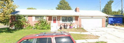 a red car parked in front of a house