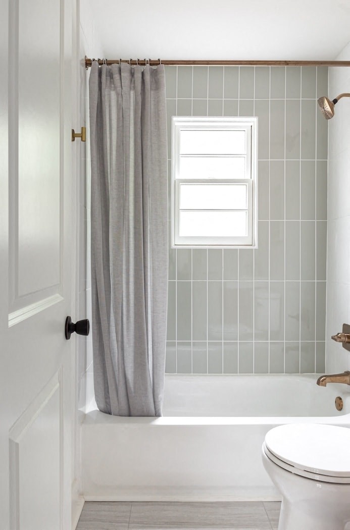 a bathroom with a toilet and a bath tub and a shower curtain