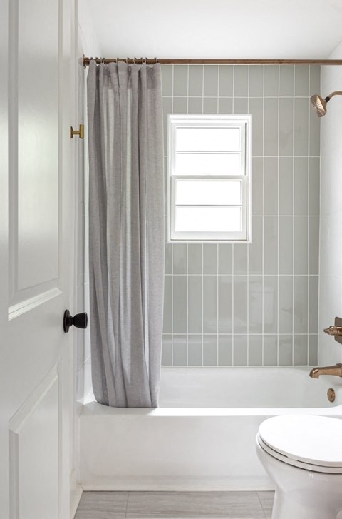 a bathroom with a toilet and a bath tub and a shower curtain