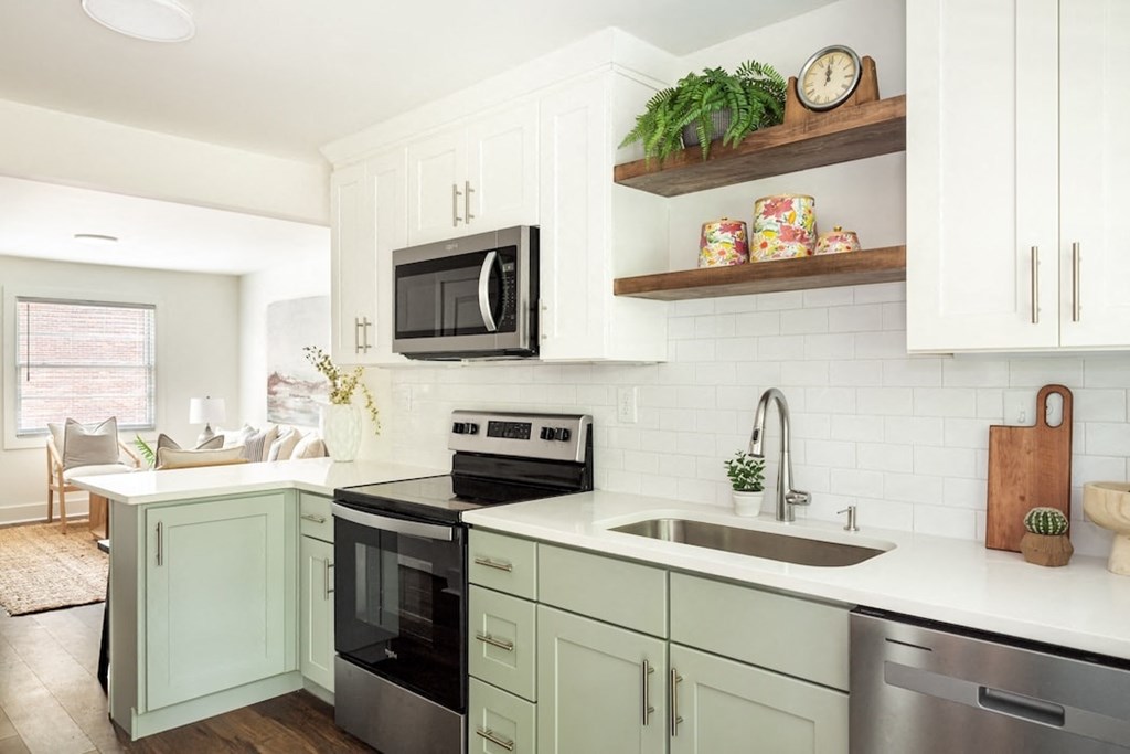 a white kitchen with stainless steel appliances and white cabinets