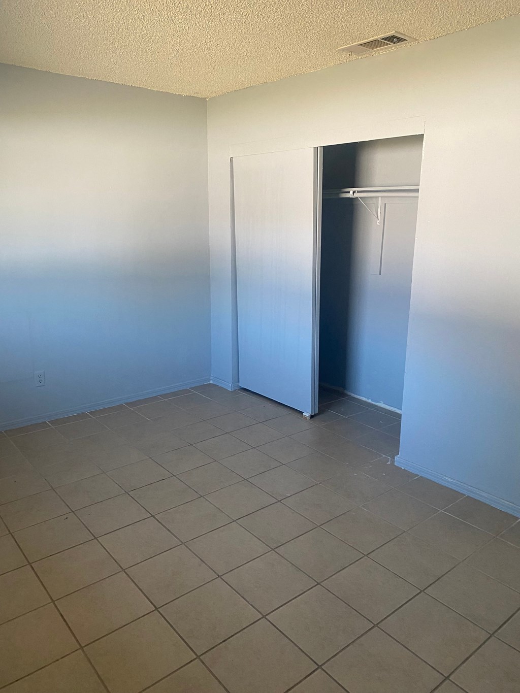 an empty room with a closet and a tiled floor