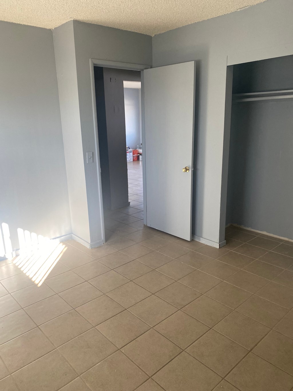 an empty hallway with two doors and a tiled floor