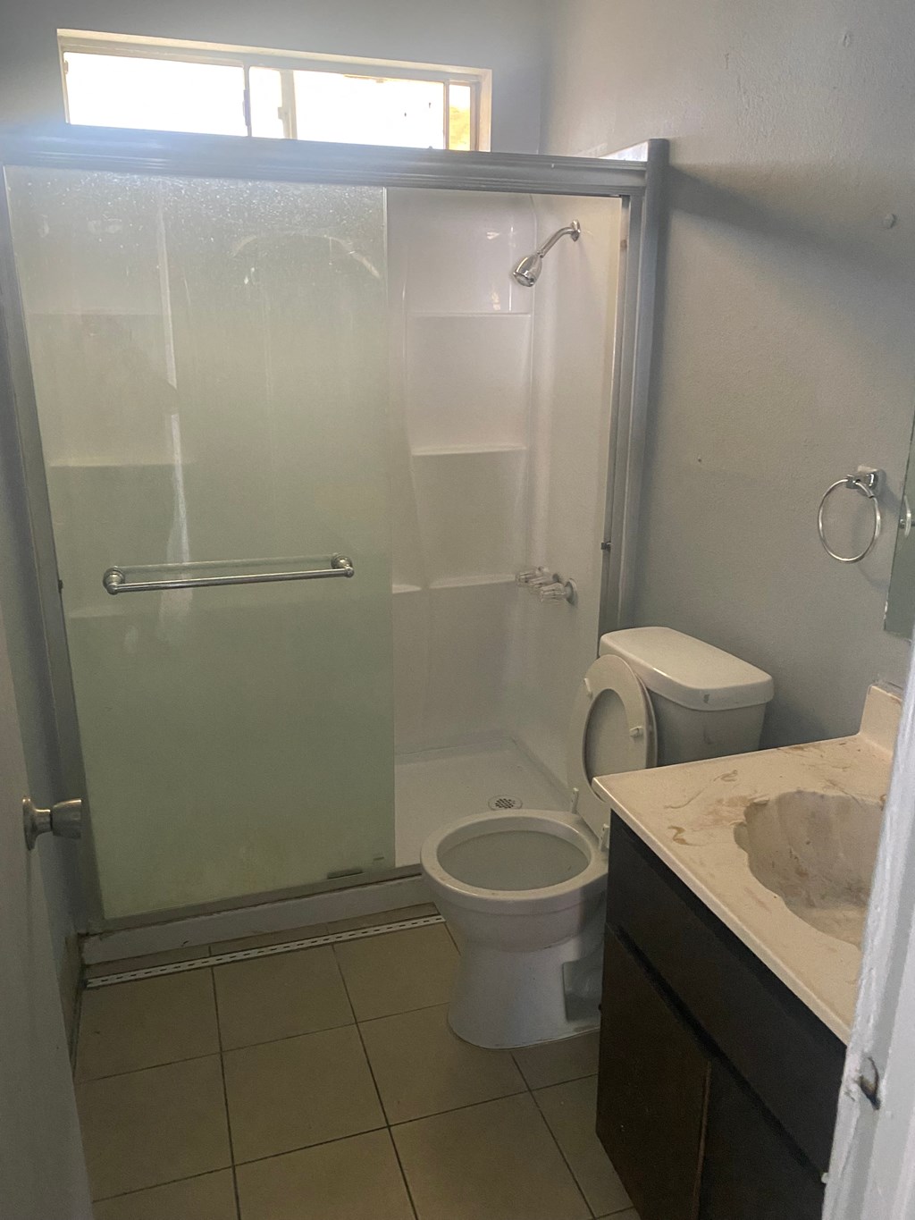 a bathroom with a shower and a toilet and a sink