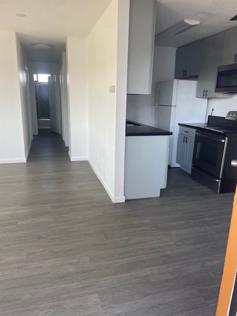 A kitchen with a black counter top and a white fridge.