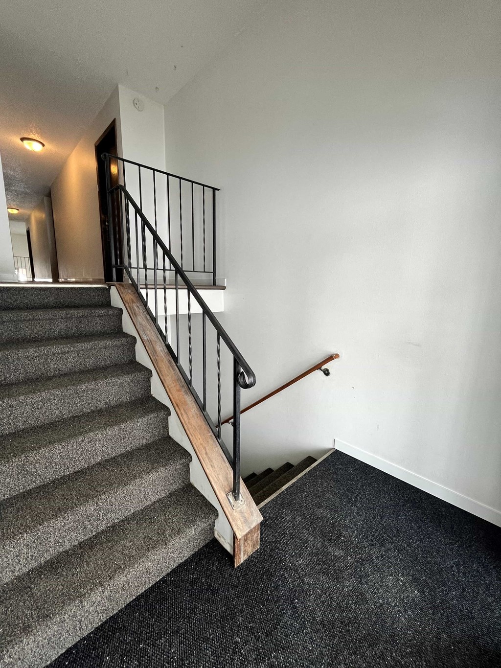 a stairwell in a home with a railing and carpeted stairs