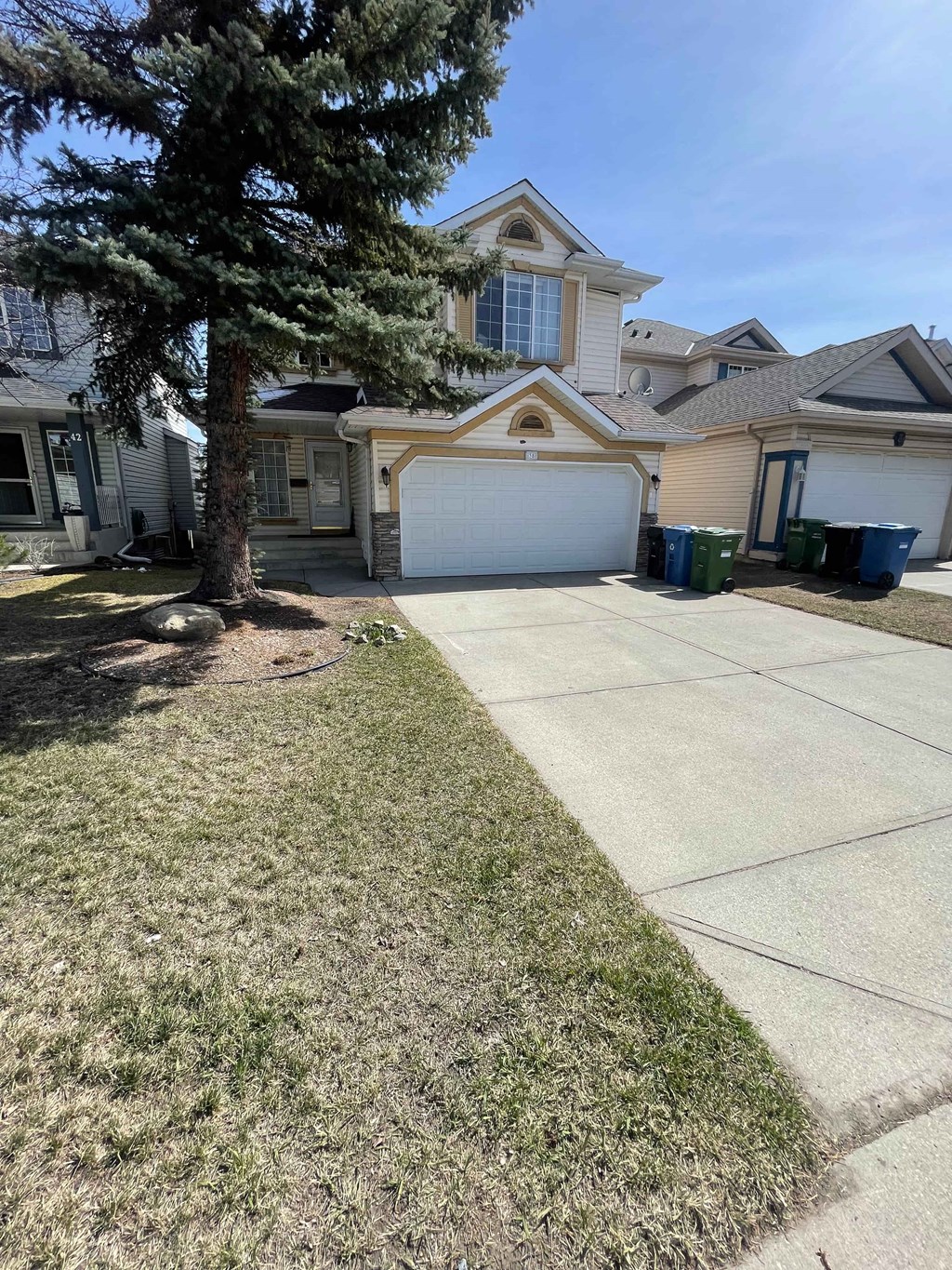 a driveway in front of a house with a tree