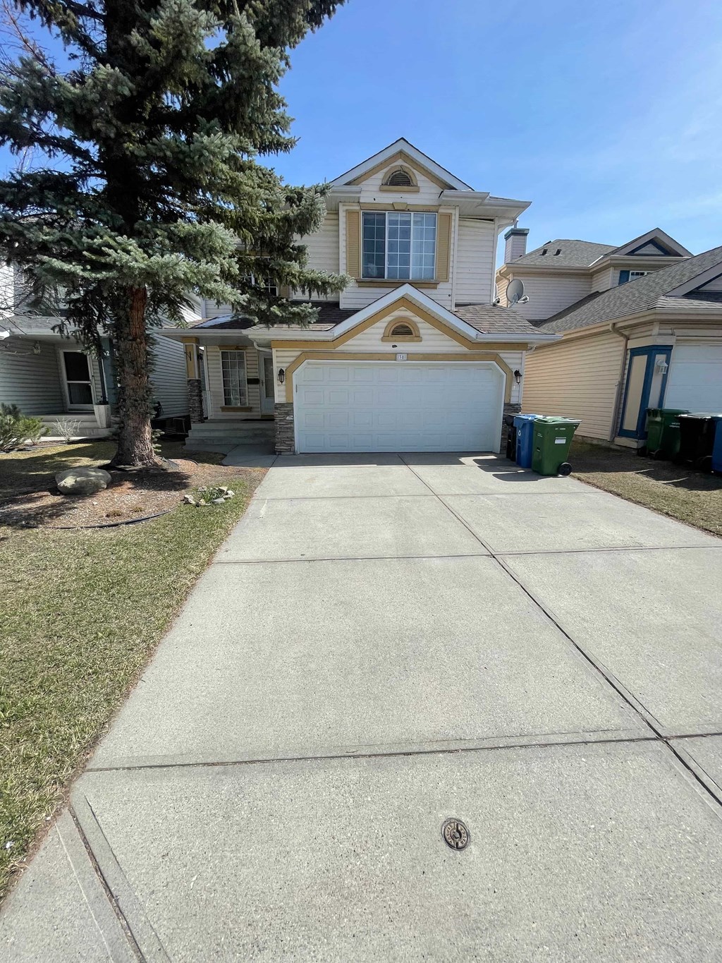 a driveway in front of a house with a white garage door