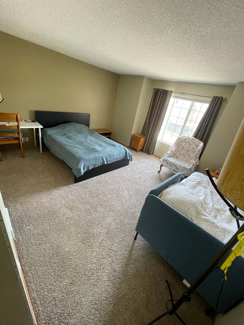 a bedroom with a couch and a bed and a chair