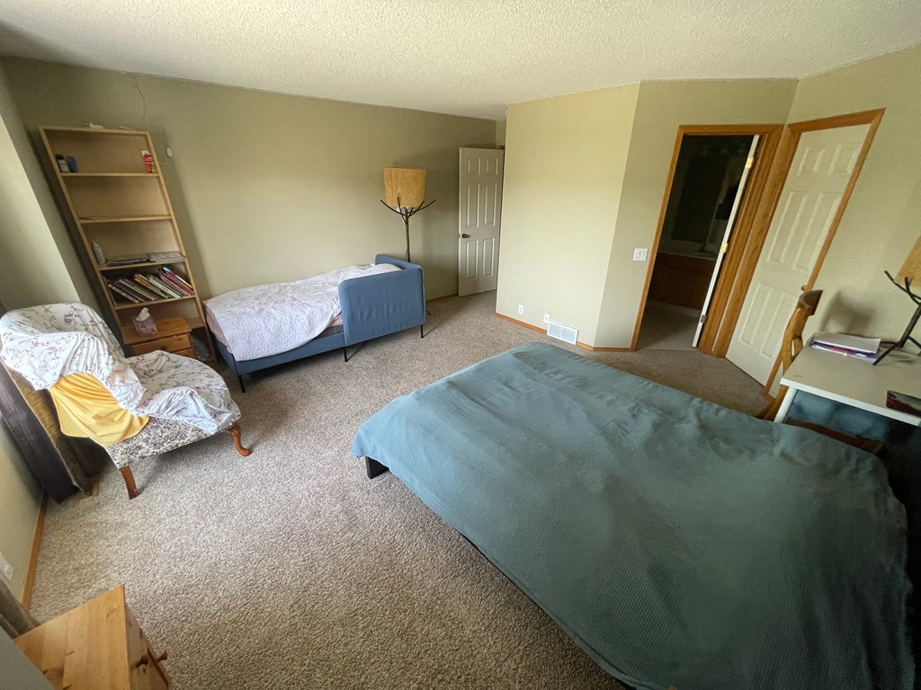 a bedroom with a bed and a chair and a closet