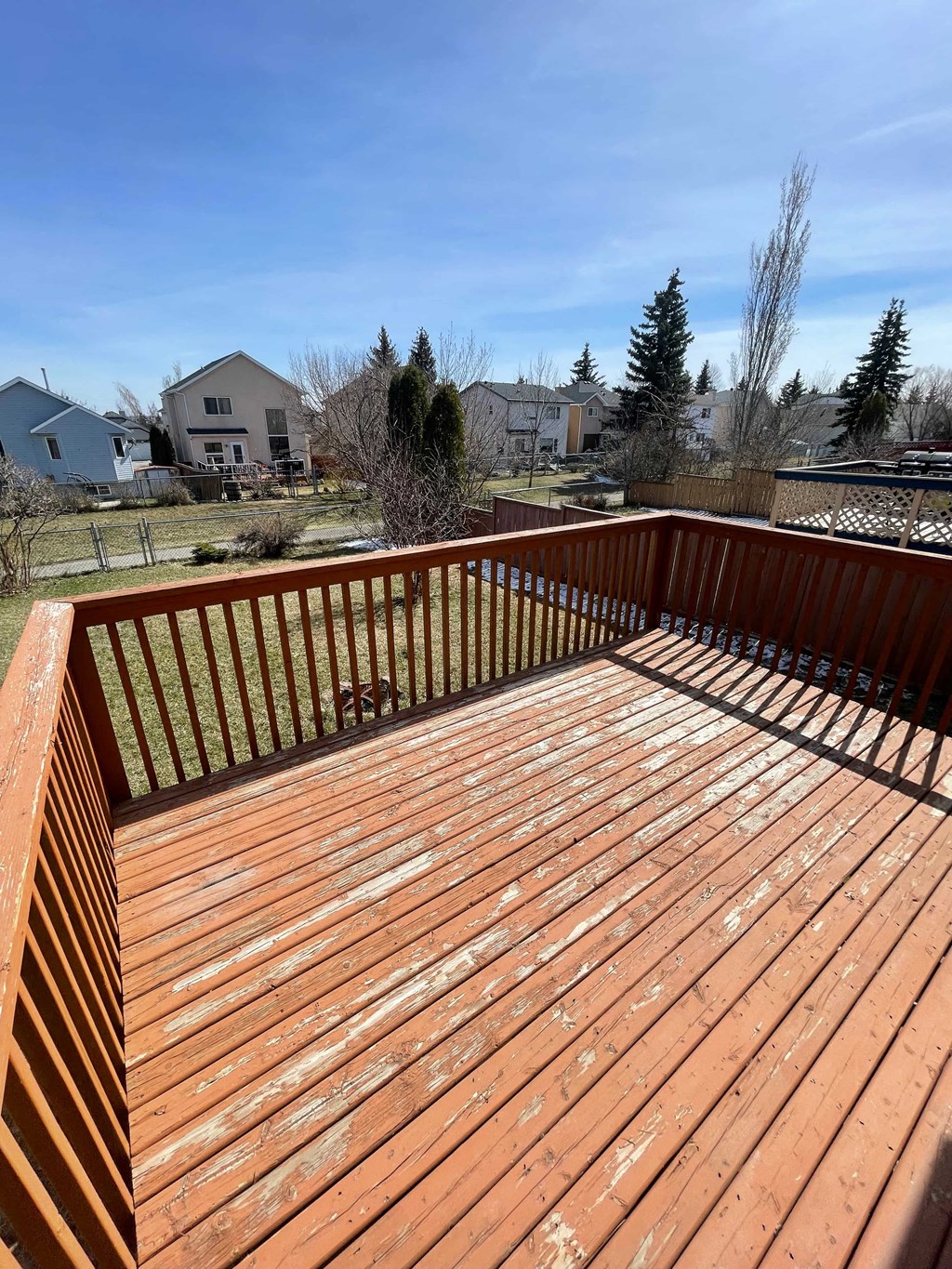a deck with a wooden railing and a blue sky