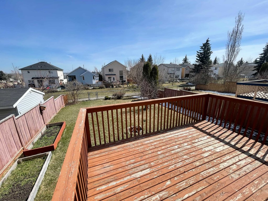 a backyard with a wooden deck and a fence