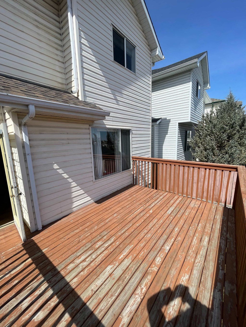 a wooden deck in front of a white house