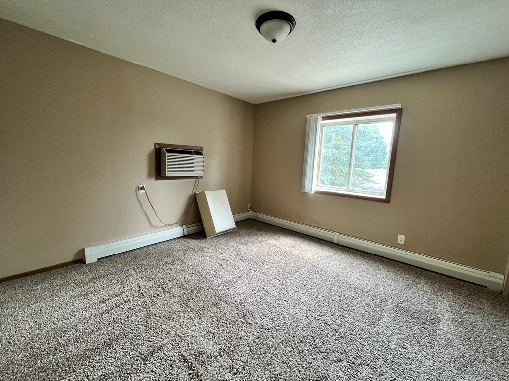 an empty room with an air conditioner and a window