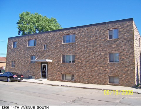 a brick building with a car parked in front of it