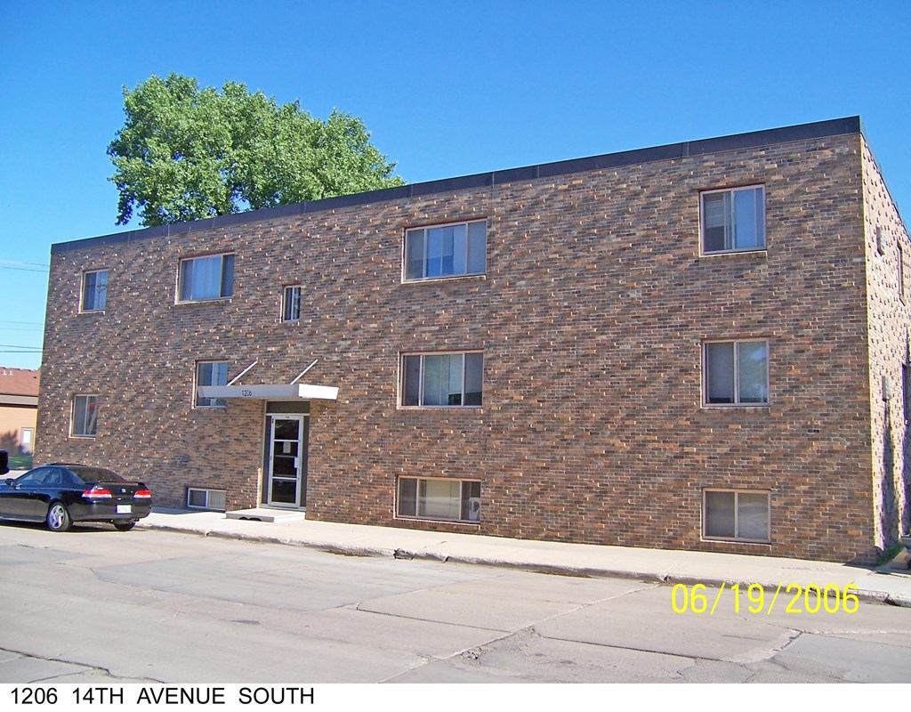 a brick building with a car parked in front of it