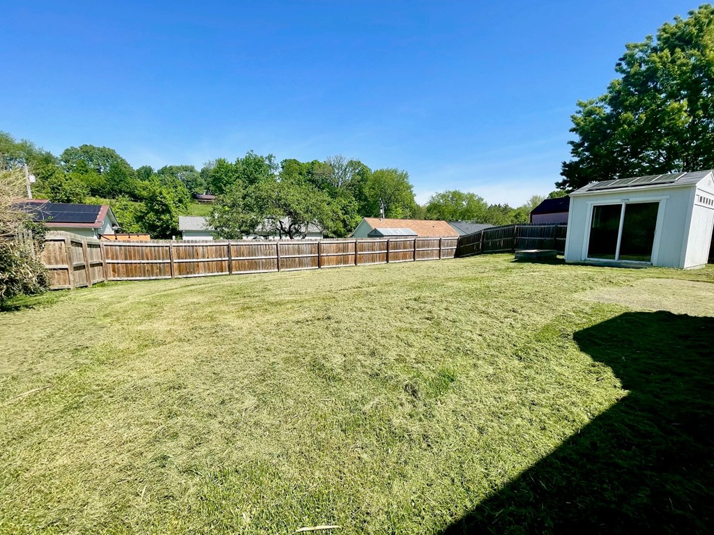 a backyard with a fenced in yard and a fence
