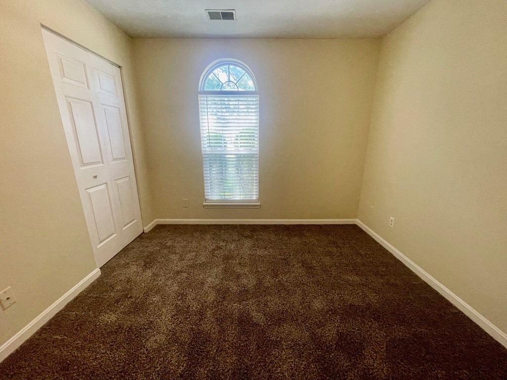 an empty room with carpet and a window