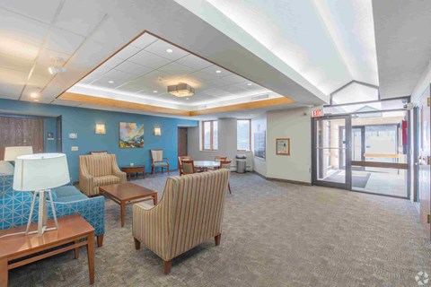 a spacious waiting room with chairs and tables in a hospital